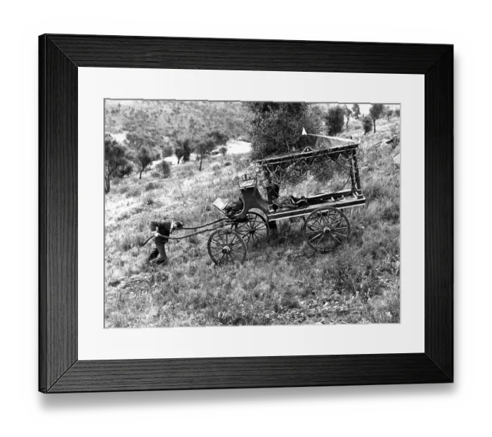 Framed Print : Man pushes a coffin carriage up the slope