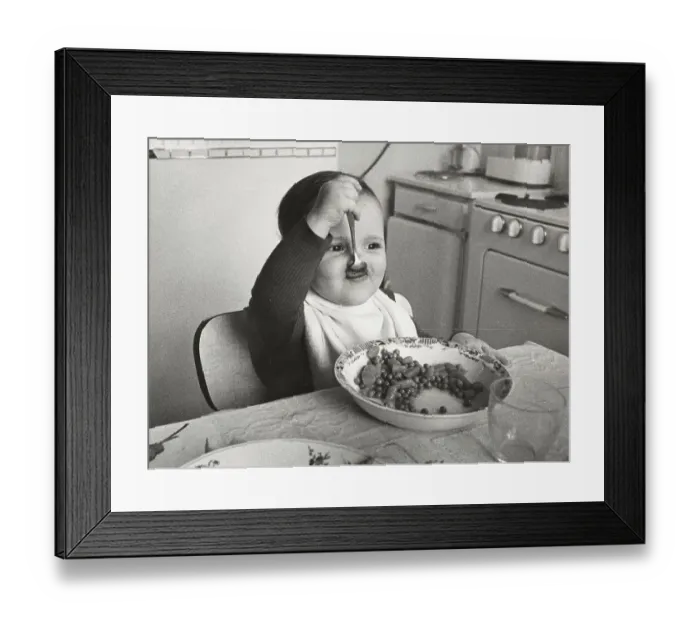 Framed Print : Toddler eats with spoon, between 50s and 60s Framed Print : Toddler eats with spoon, between 50s and 60s