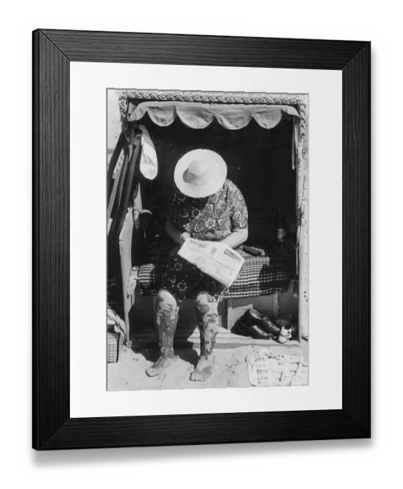 Framed Print : Grandma reads newspaper in a beach chair