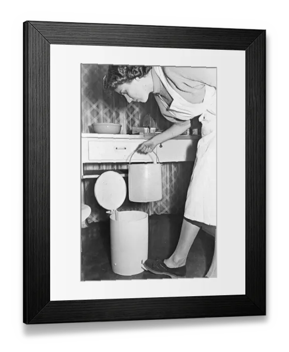 Framed Print : Housewife empties the trash can, ca Framed Print : Housewife empties the trash can, ca
