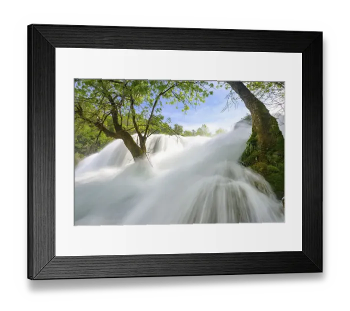 Framed Print : Dynamic water cascading powerfully through a green forest landscape