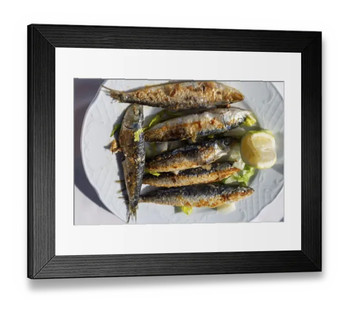 Framed Print : Looking down from overhead on white plate of freshly grilled sardines