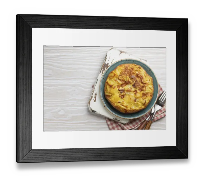 Framed Print : Homemade Spanish tortilla - omelette with potatoes on plate on white wooden rustic background top view