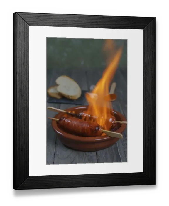 Framed Print : Typical spanish tapa, chorizo on fire in an earthenware casserole with slices of bread in the background Framed Print : Typical spanish tapa, chorizo on fire in an earthenware casserole with slices of bread in the background