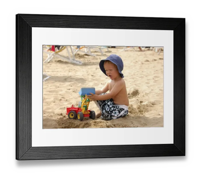 Framed Print : Little boy sitting on the beach playing