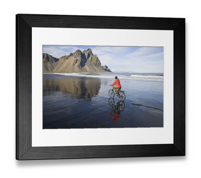 Framed Print : Woman riding a bicycle on the beach in front of Mt Vestrahorn near Hoefn Framed Print : Woman riding a bicycle on the beach in front of Mt Vestrahorn near Hoefn