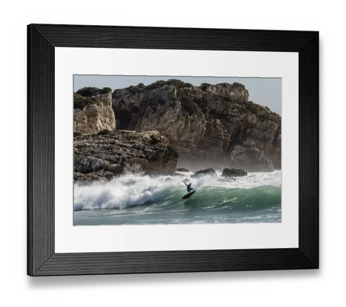 Framed Print : Surfer in the surf off the rocky coast
