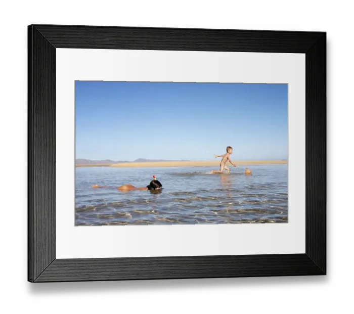 Framed Print : Boy, 4 years, trying to catch fish with a net