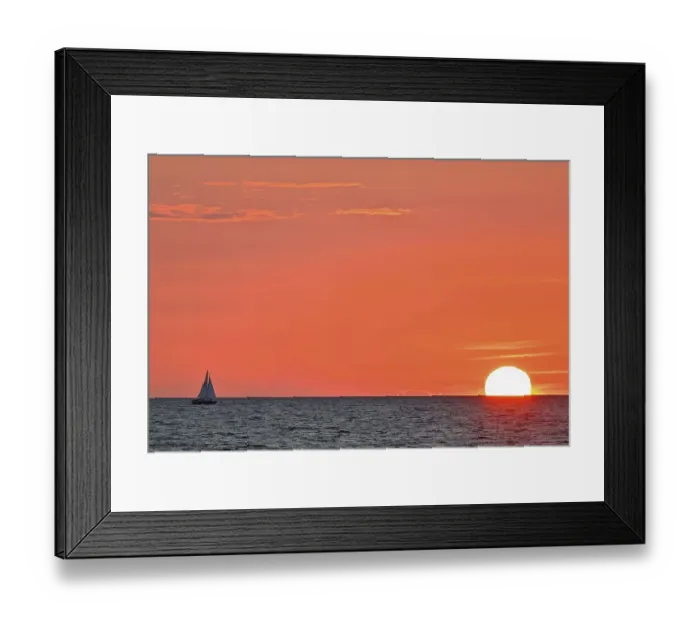 Framed Print : Sailboat sailing in the evening towards the setting sun