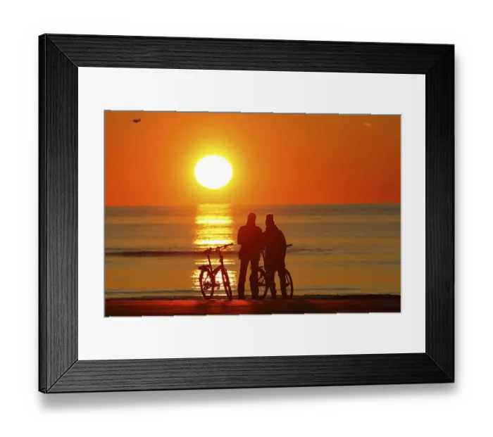 Framed Print : Couples with bikes on the beach watching the sunset