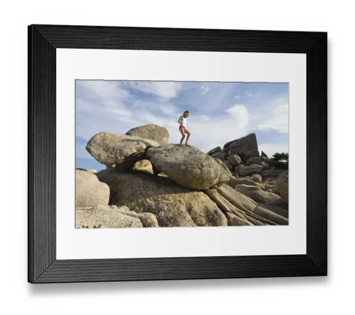 Framed Print : 7-year-old girl climbing on the rocks at the beach of Palombaggia Framed Print : 7-year-old girl climbing on the rocks at the beach of Palombaggia