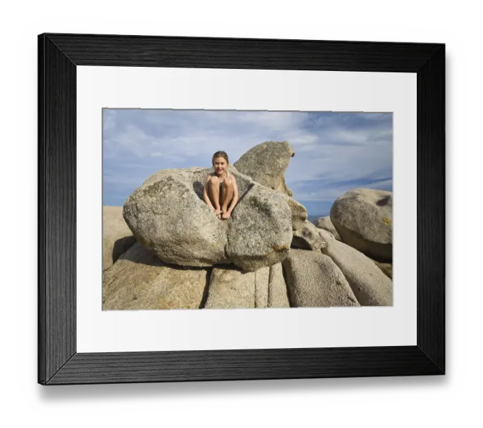 Framed Print : 7-year-old girl climbing on the rocks at the beach of Palombaggia Framed Print : 7-year-old girl climbing on the rocks at the beach of Palombaggia
