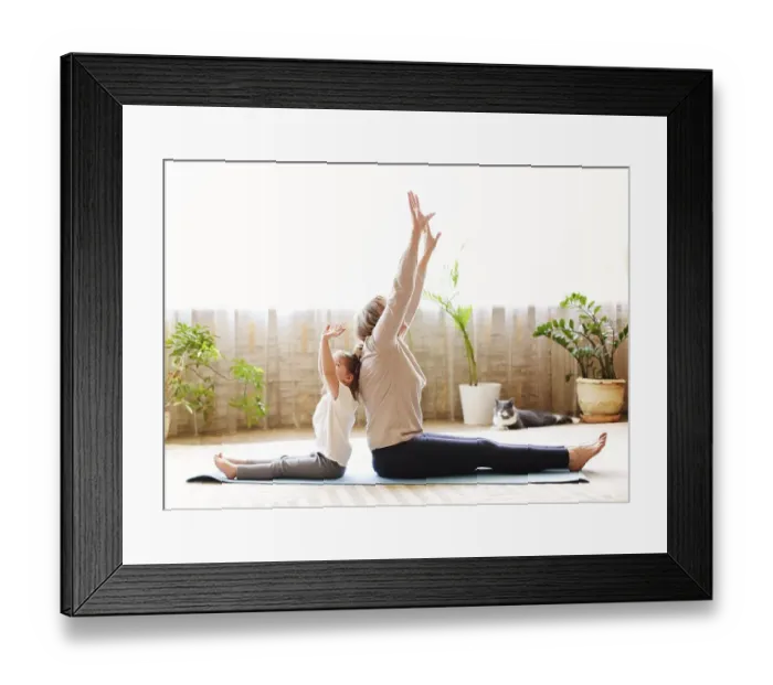 Framed Print : Mature woman and little girl sitting on mat in lotus pose