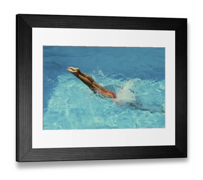 Framed Print : Young woman jumps into the swimming pool