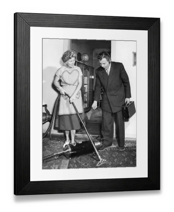 Framed Print : Representative and housewife with vacuum cleaner