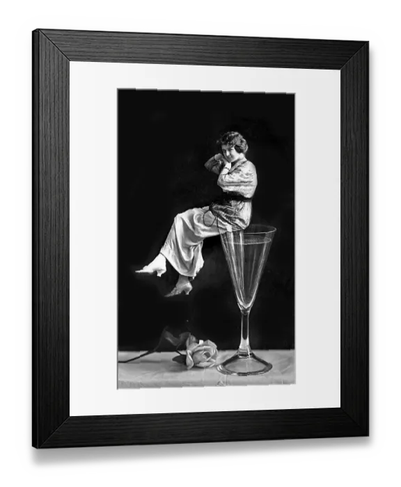 Framed Print : Woman sitting on a champagne glass