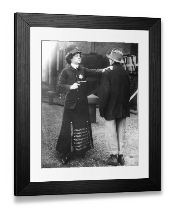 Framed Print : Woman with a gun and disguised as a policewoman arrests a man Framed Print : Woman with a gun and disguised as a policewoman arrests a man