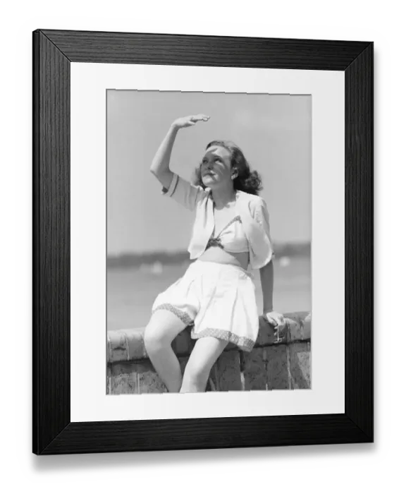 Framed Print : Holiday, swimwear, woman in beachwear protects herself from the sun Framed Print : Holiday, swimwear, woman in beachwear protects herself from the sun