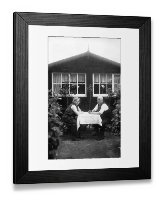 Framed Print : Couple, older couple sitting in the allotment garden at the table in front of the arbour