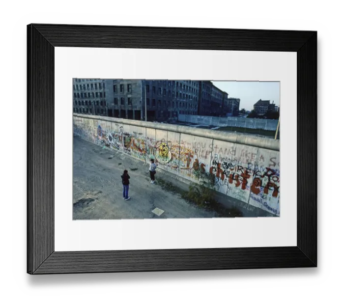 Framed Print : Man photographs a woman at the Berlin Wall