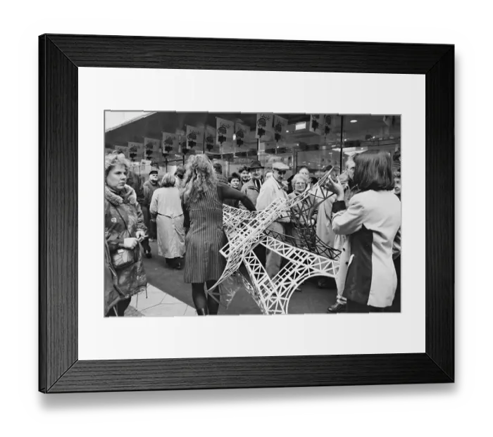 Framed Print : Employees carry a model of the Eiffel Tower across the pavement at the opening of the French department stores