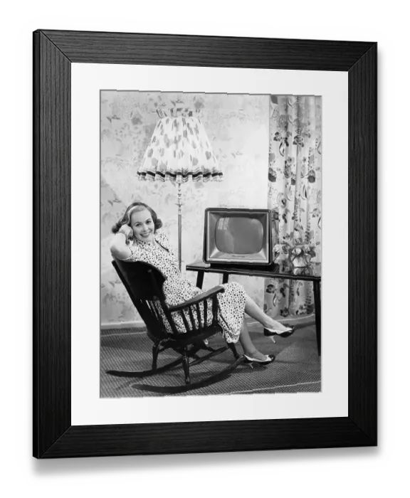 Framed Print : Woman sitting in front of a television in a rocking chair Framed Print : Woman sitting in front of a television in a rocking chair
