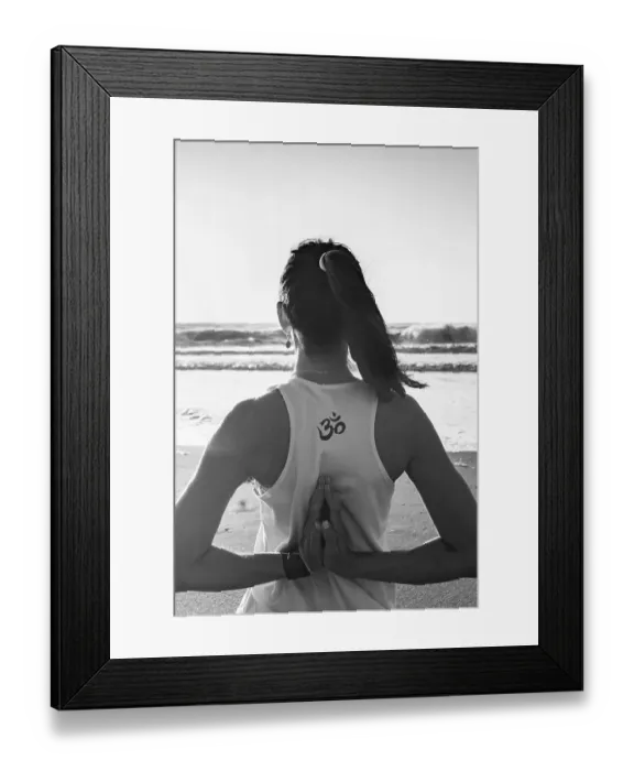 Framed Print : Rearview shot of a young woman practicing yoga at the beach