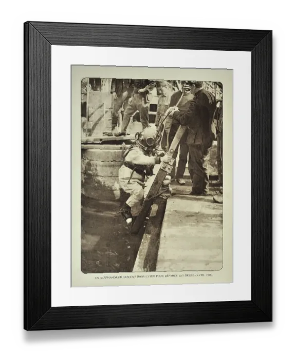 Framed Print : Diver wearing helmet descends ladder to repair the dikes along the river Yser