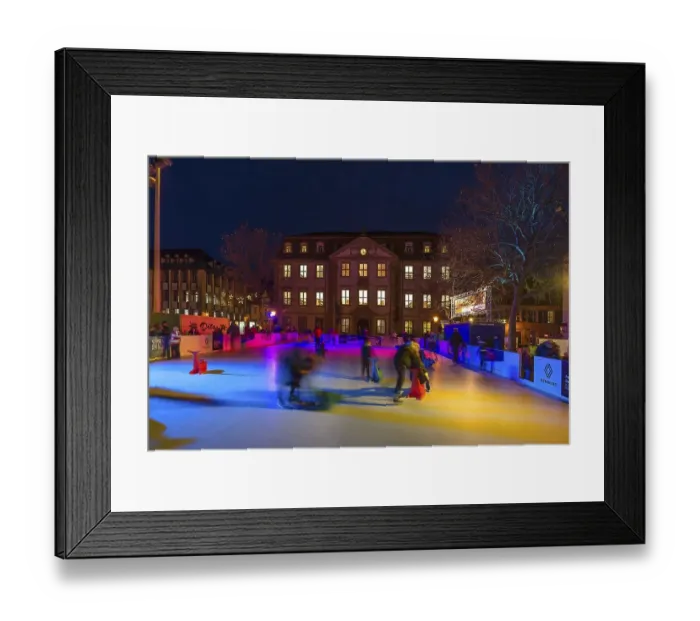 Framed Print : Skaters on a colourfully illuminated artificial ice rink Framed Print : Skaters on a colourfully illuminated artificial ice rink