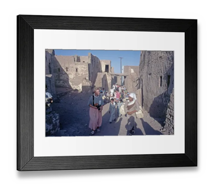 Framed Print : Children accompany tourists, houses Framed Print : Children accompany tourists, houses