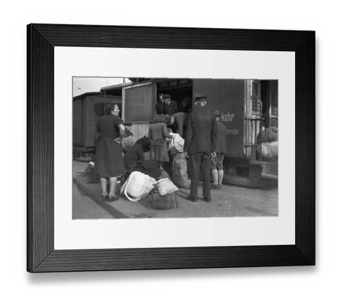 Framed Print : Refugees load their belongings into the freight cars of the tram