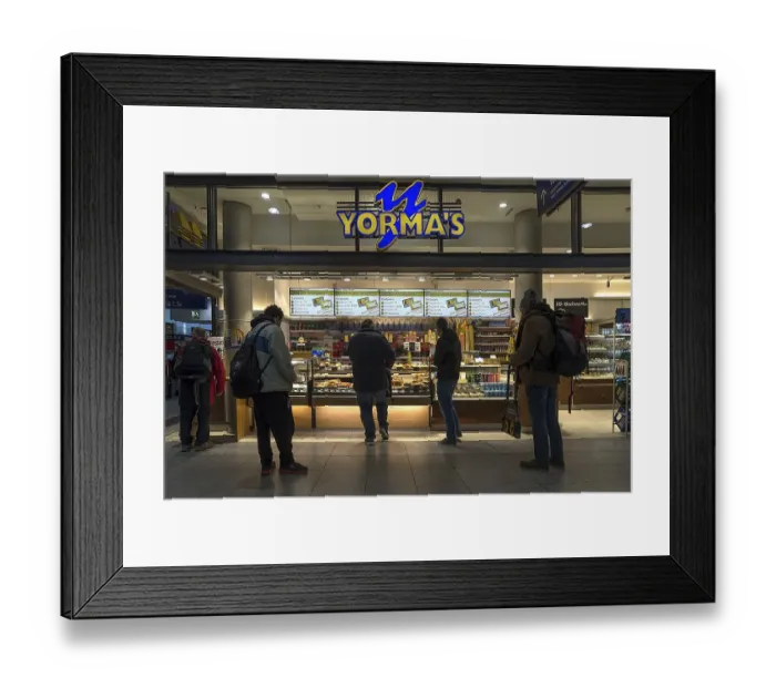 Framed Print : Travellers in front of a stall in a railway station