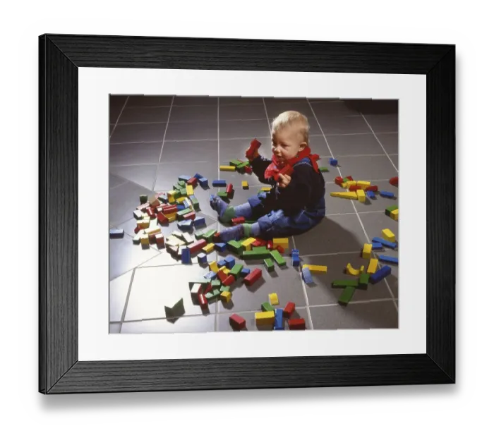 Framed Print : Toddler playing with building blocks
