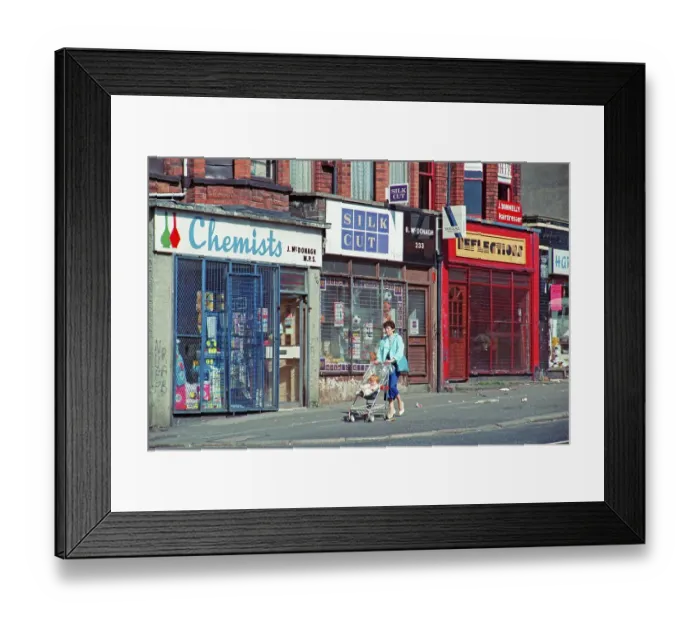 Framed Print : Woman with pram in front of barred shops