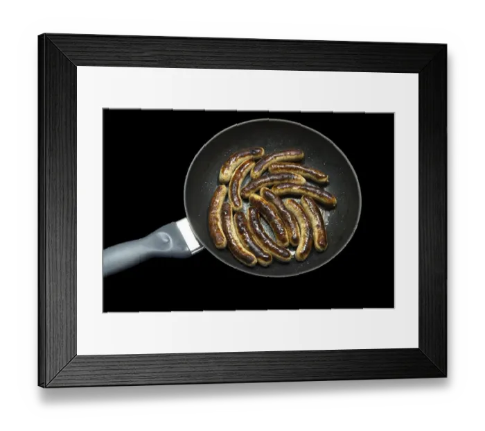 Framed Print : Freshly roasted Nuremberg sausages in a pan