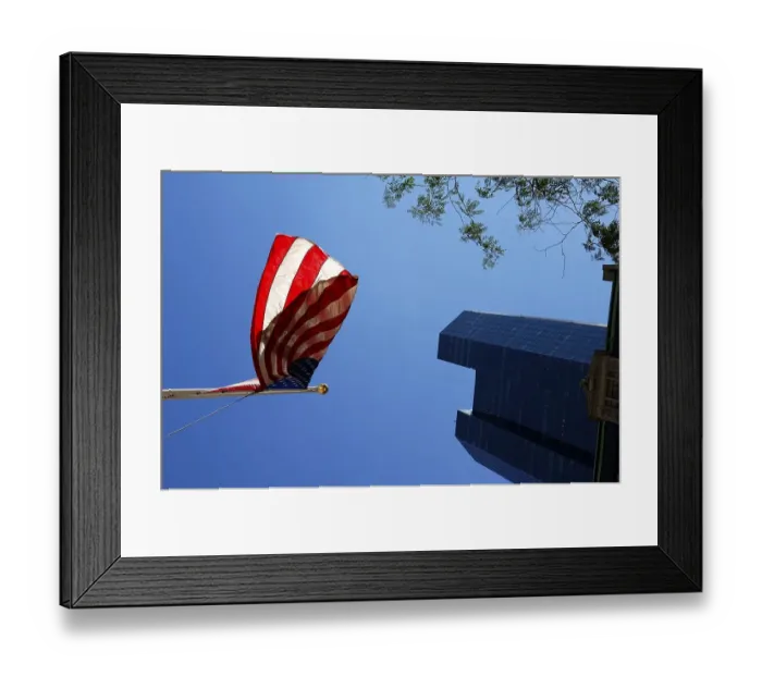 Framed Print : Waving US flags backlit with skyscraper