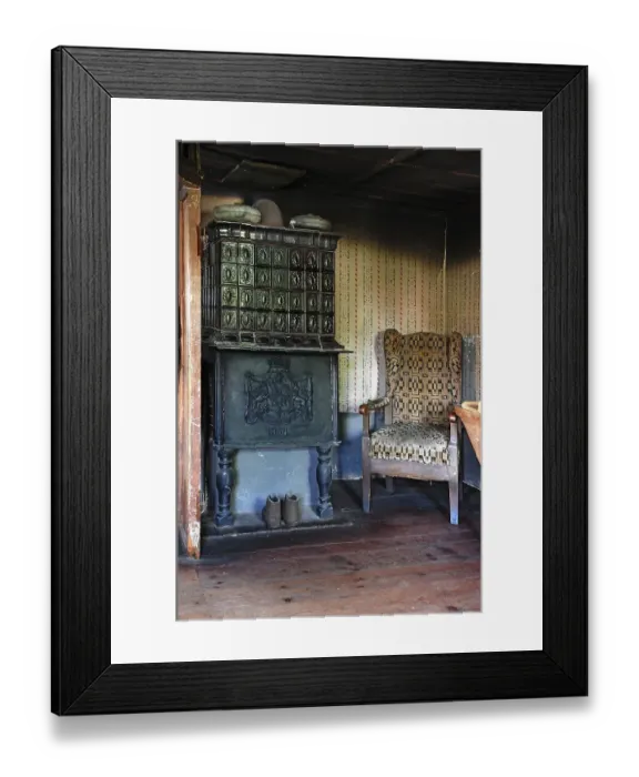 Framed Print : Parlour with tiled stove from 1854 and armchair in a farmhouse