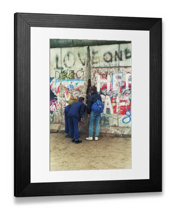 Framed Print : 12.11.1989 GDR Mitte district. Three young people look through a hole in the wall into the GDR