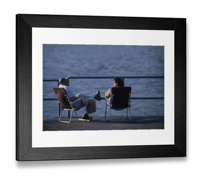 Framed Print : Couple sitting by the sea