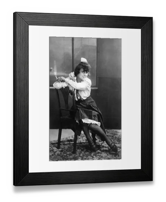 Framed Print : Young, pretty woman sitting on a chair smoking