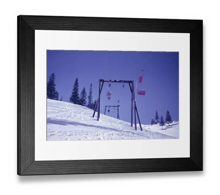 Framed Print : Old chairlift in the snow, with a ski slope underneath