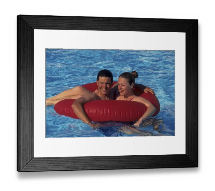 Framed Print : Young couple frolicking with red floaty tyre in swimming pool Framed Print : Young couple frolicking with red floaty tyre in swimming pool