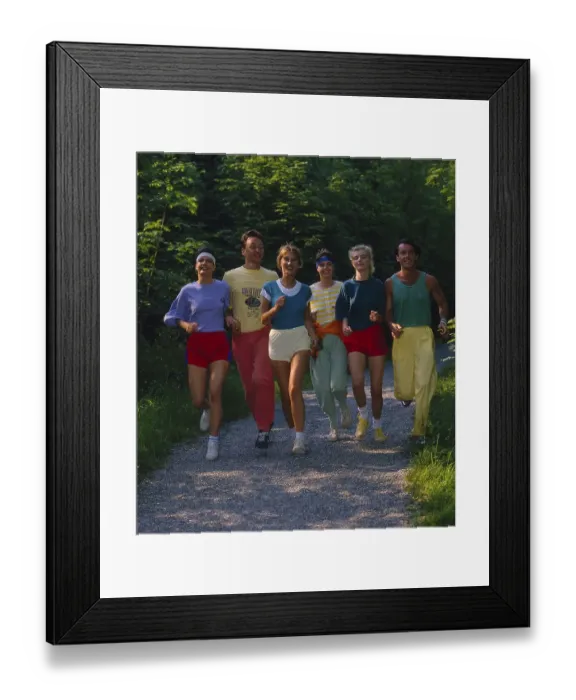 Framed Print : Young people jogging through flower meadow