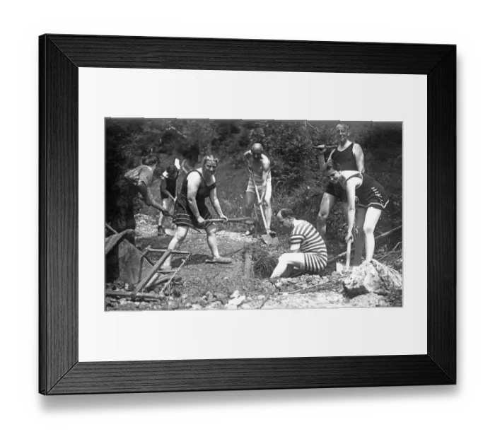 Framed Print : Men and women dig a hole wearing swimwear Framed Print : Men and women dig a hole wearing swimwear