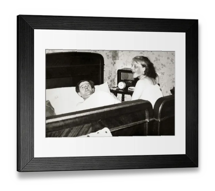 Framed Print : Couple in bedroom, man is lying in bed