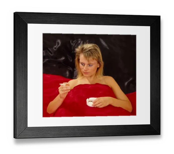 Framed Print : Woman smoking cigarette in bed