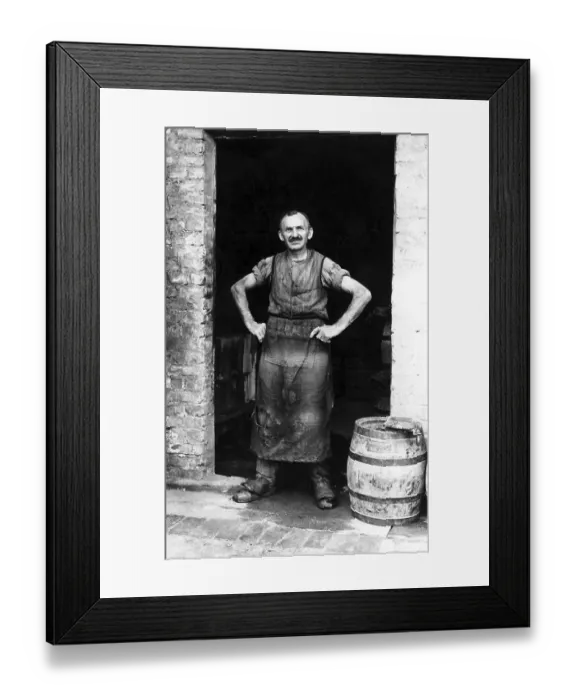 Framed Print : Handicraft, barrel maker stands in the door of his workshop