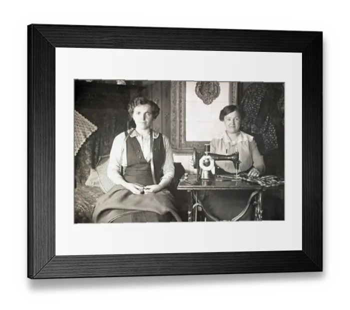 Framed Print : Two women work on the sewing machine