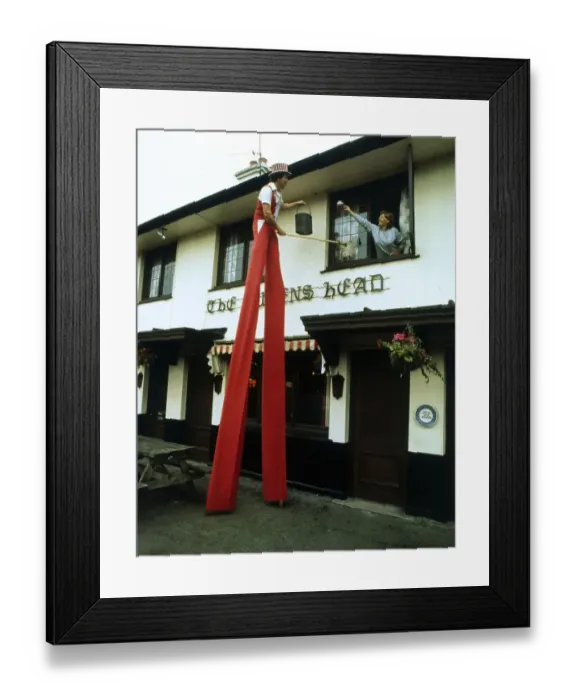 Framed Print : Man on stilts cleaning windows Framed Print : Man on stilts cleaning windows