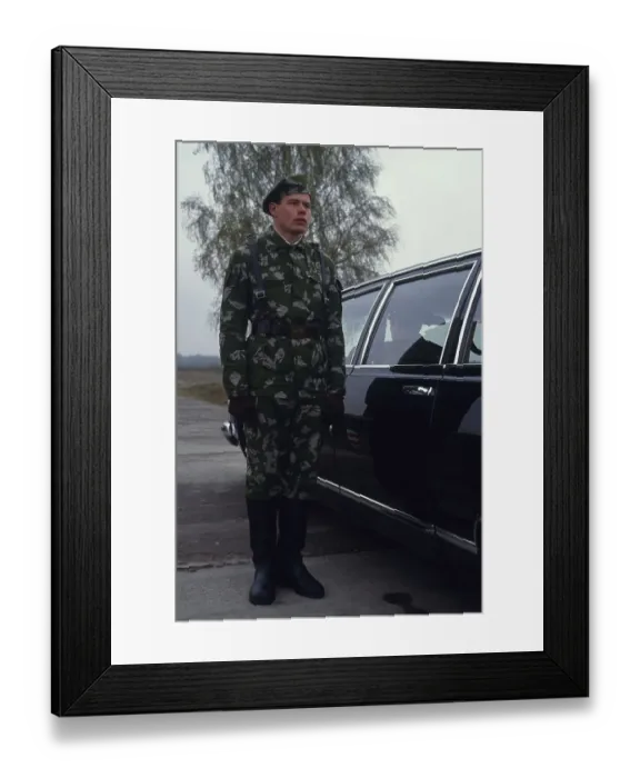 Framed Print : Russian soldier standing beside a car